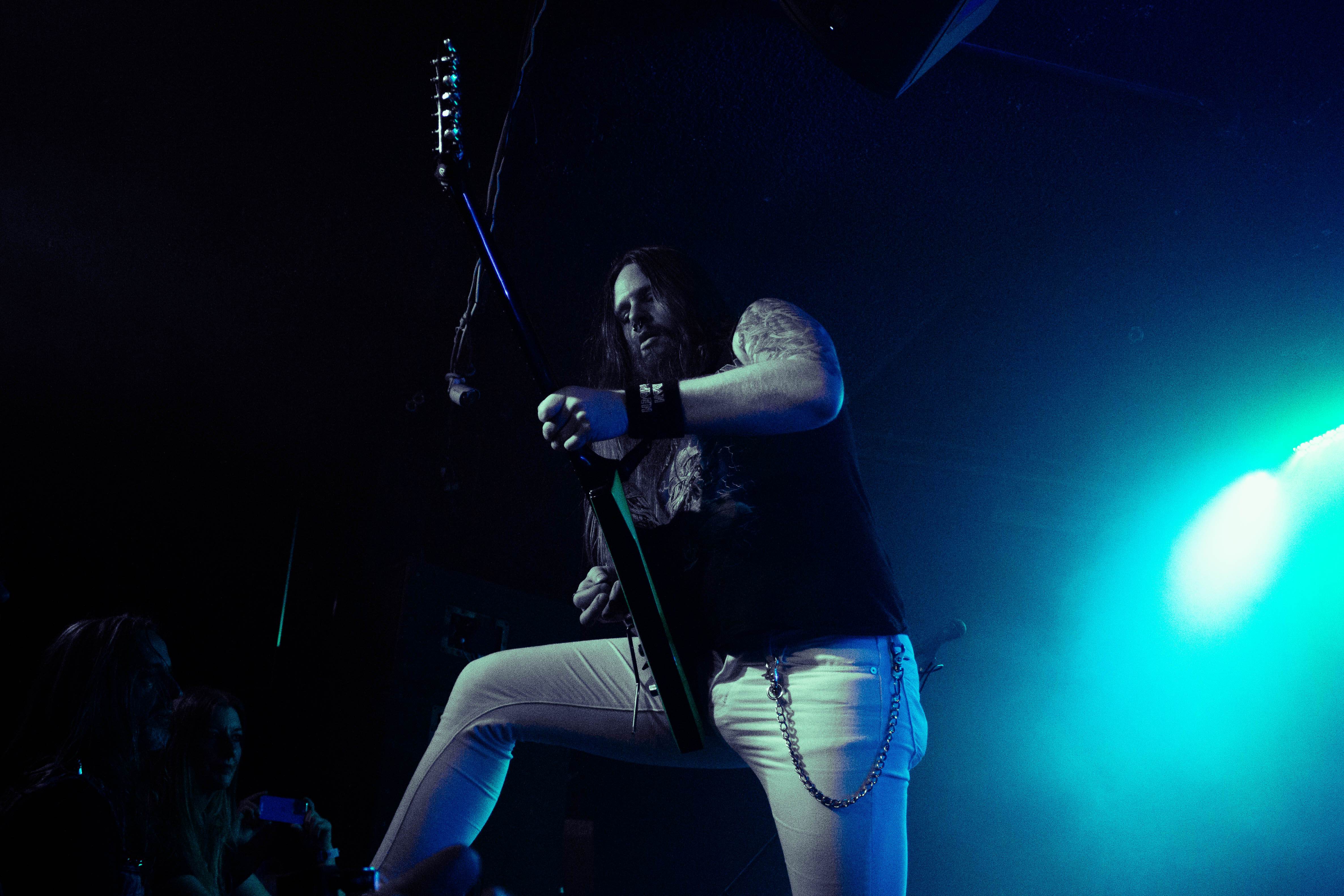 Aces High's guitarist in blue light standing on the crowd barrier